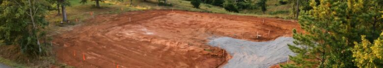 Cleared land ready for construction in Central Virginia, showcasing soil preparation and site work for custom home building.
